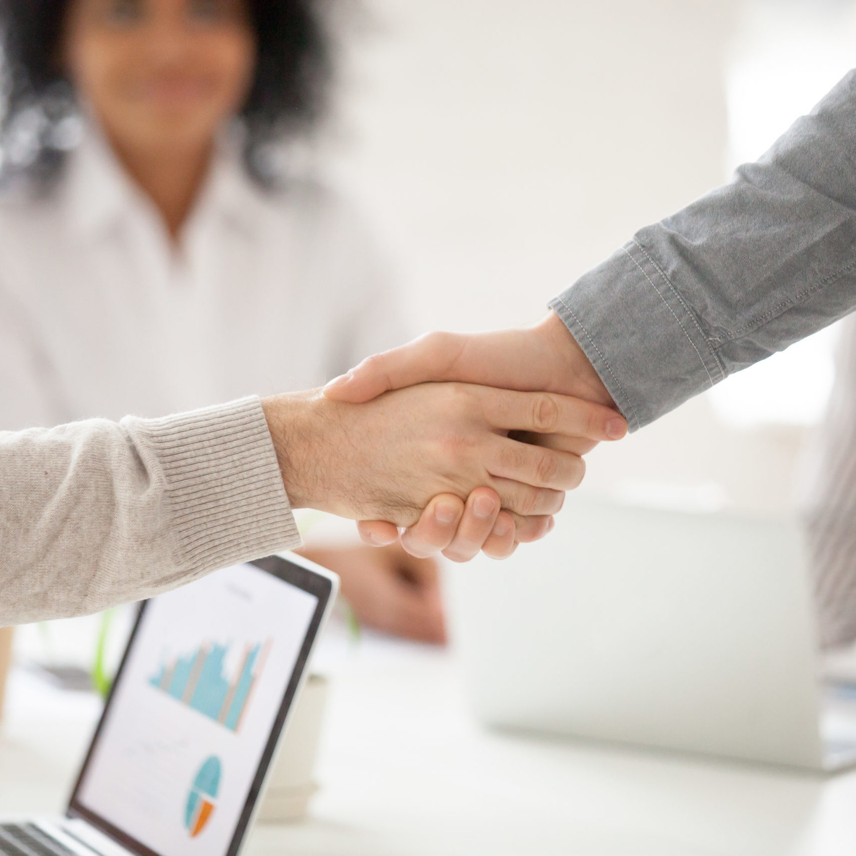Two business partners handshake at group meeting making online project investment, male hands shake as concept of successful collaboration result or starting partnership after effective negotiations